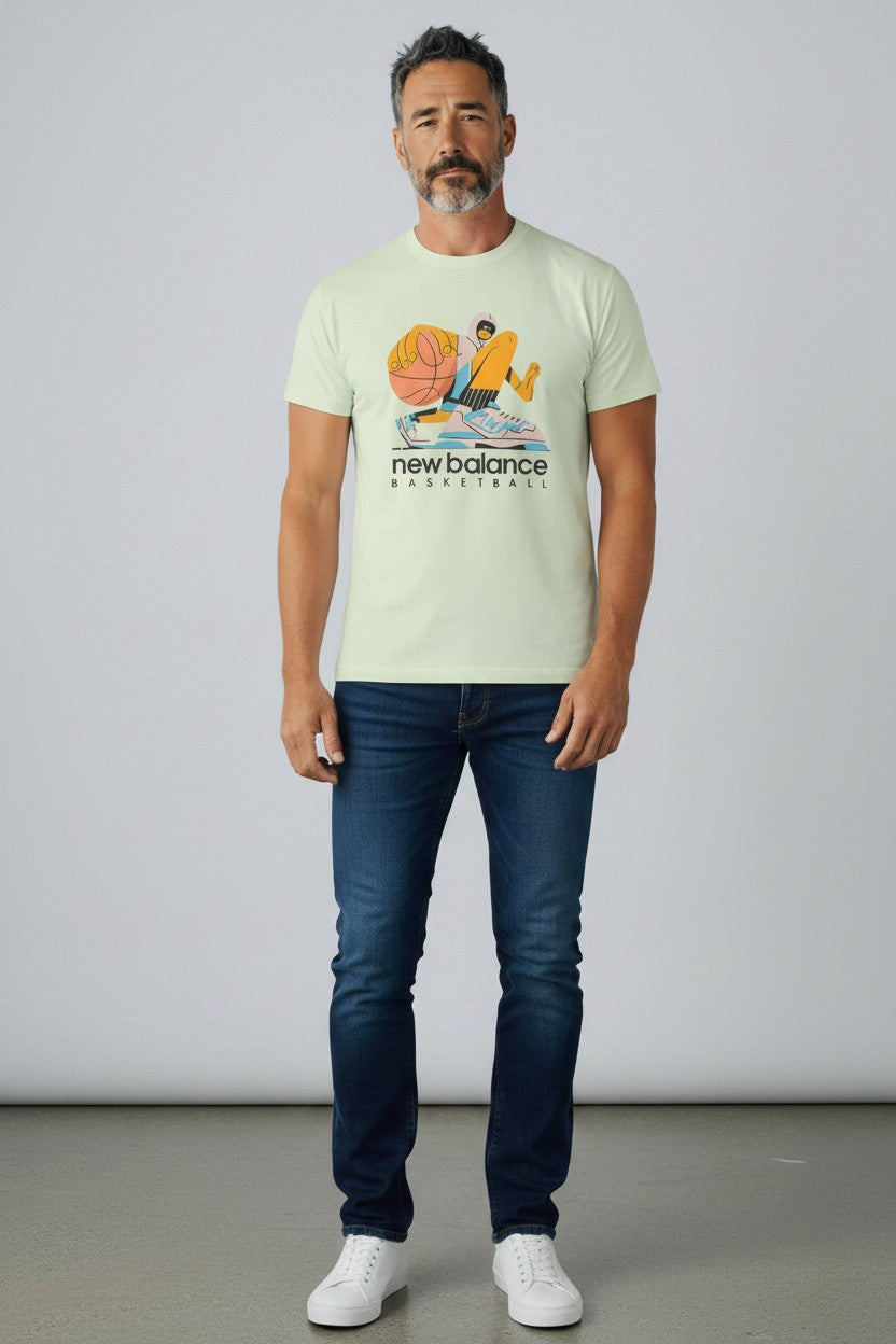 Man wearing a light green t-shirt with a graphic design and text, standing against a plain background. New Balance, Monza Outlet, Monza Fashion, Shein Outlet