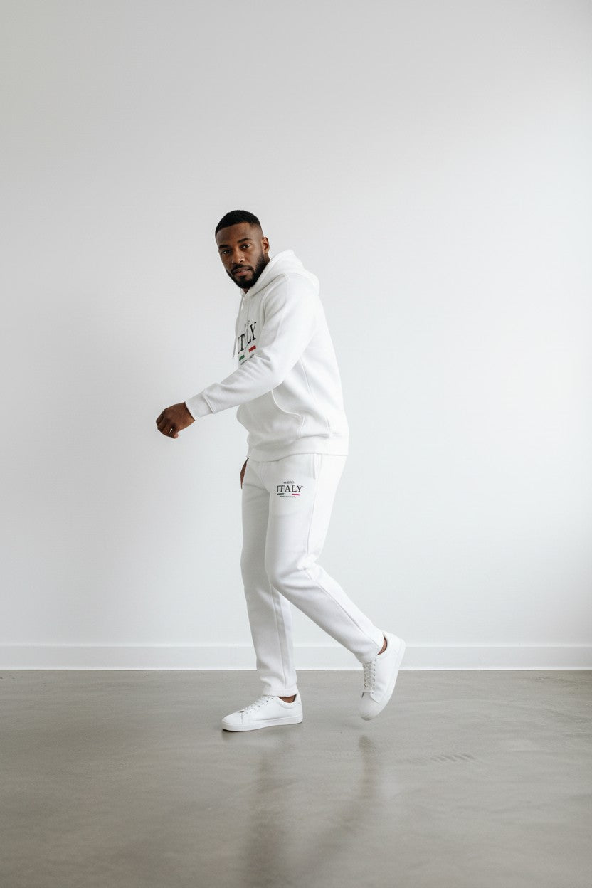 Person wearing a white tracksuit with brand logos on a plain background. Antler, Monza Outlet, Monza Fashion, Shein Outlet
