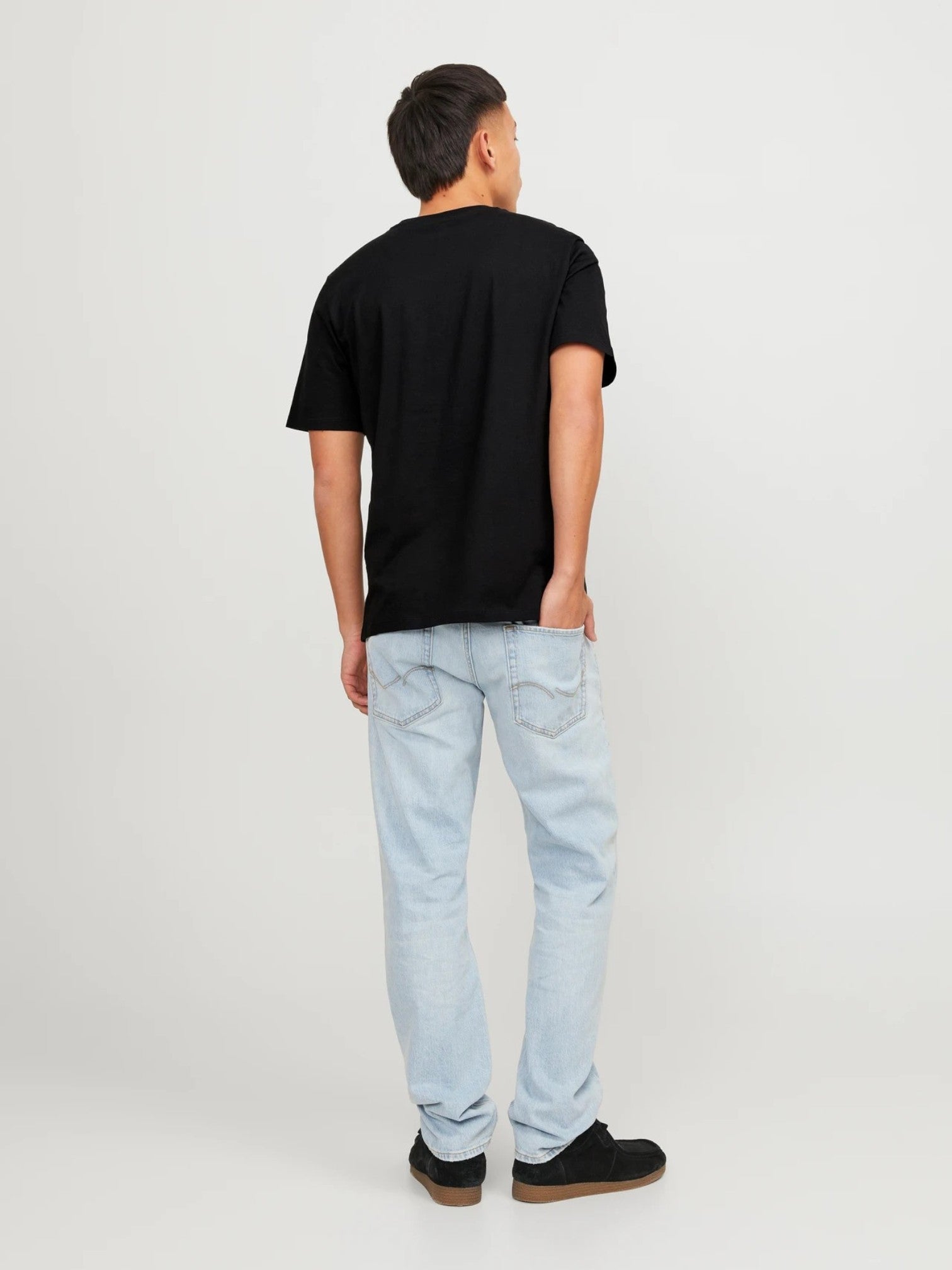Person wearing a black t-shirt and light blue jeans on a white background.  Jack & Jones, Monza Outlet, Monza Fashion, Shein Outlet 