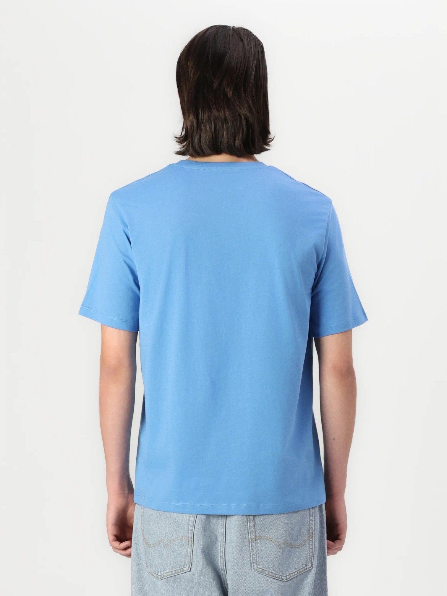 Person wearing a light blue t-shirt on a white background. Jack & Jones, Monza Outlet, Monza Fashion, Shein Outlet 