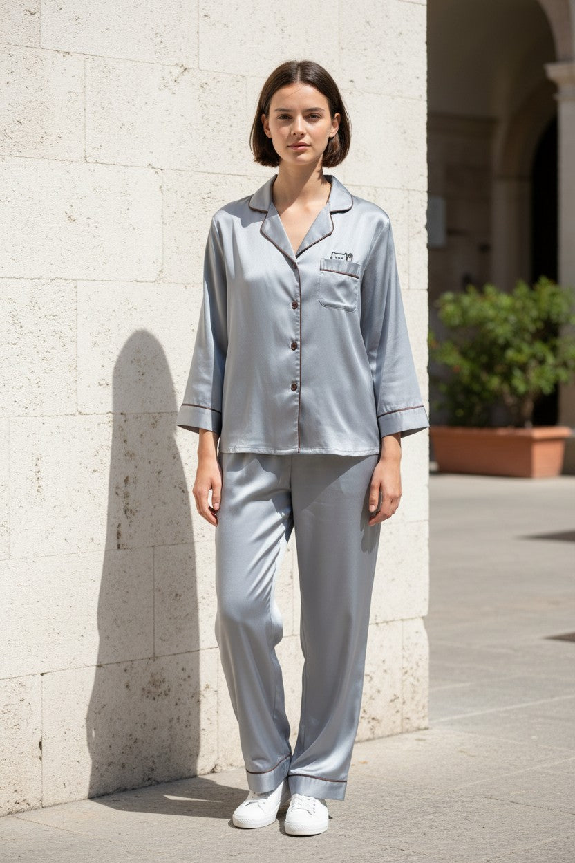 Woman wearing a light gray pajama set standing against a stone wall. Monza Italy, Monza Outlet, Monza Fashion, Shein Outlet