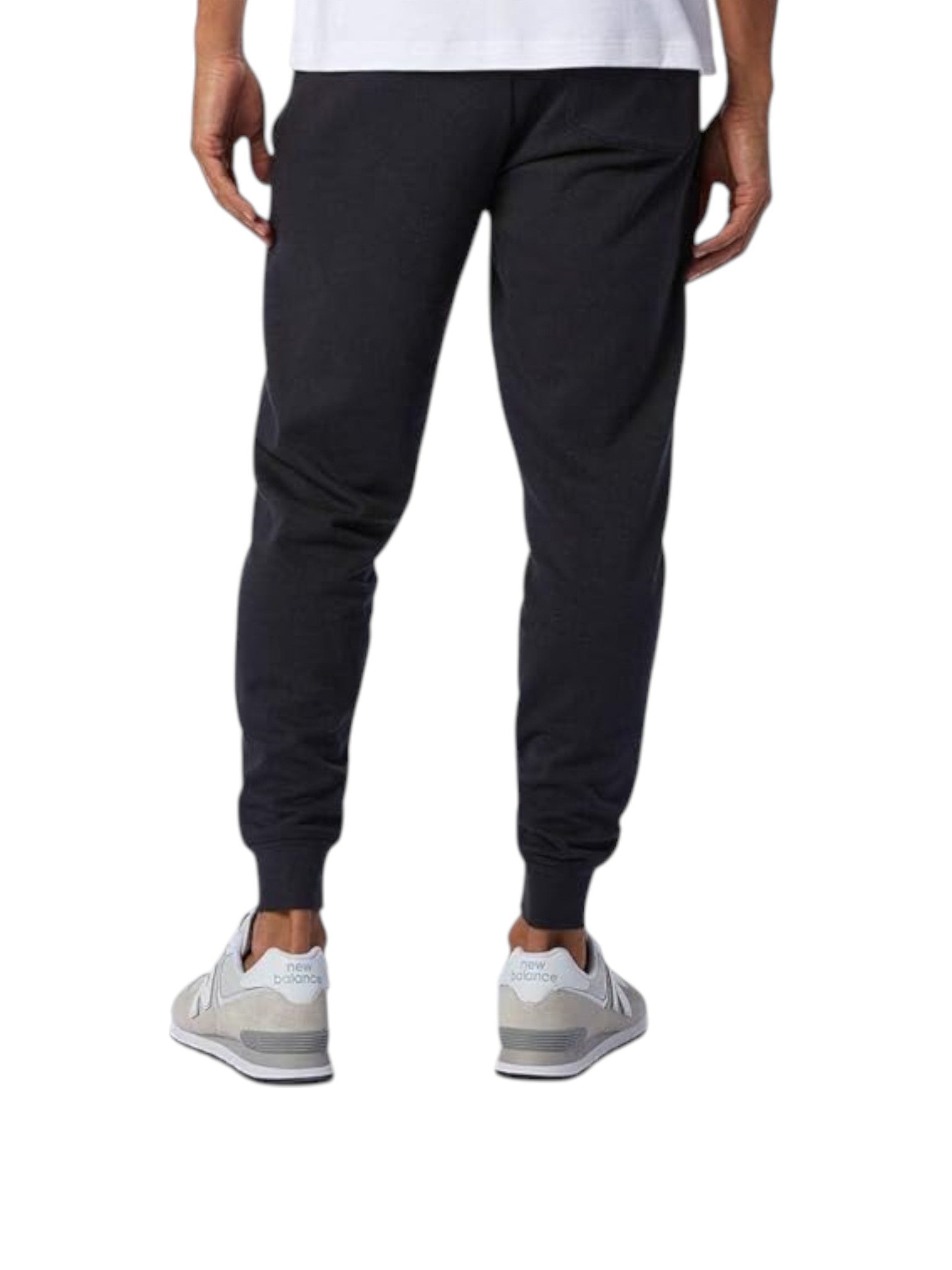 Person wearing black jogger pants and white sneakers on a white background. New Balance, Monza Outlet, Monza Fashion, Shein Outlet