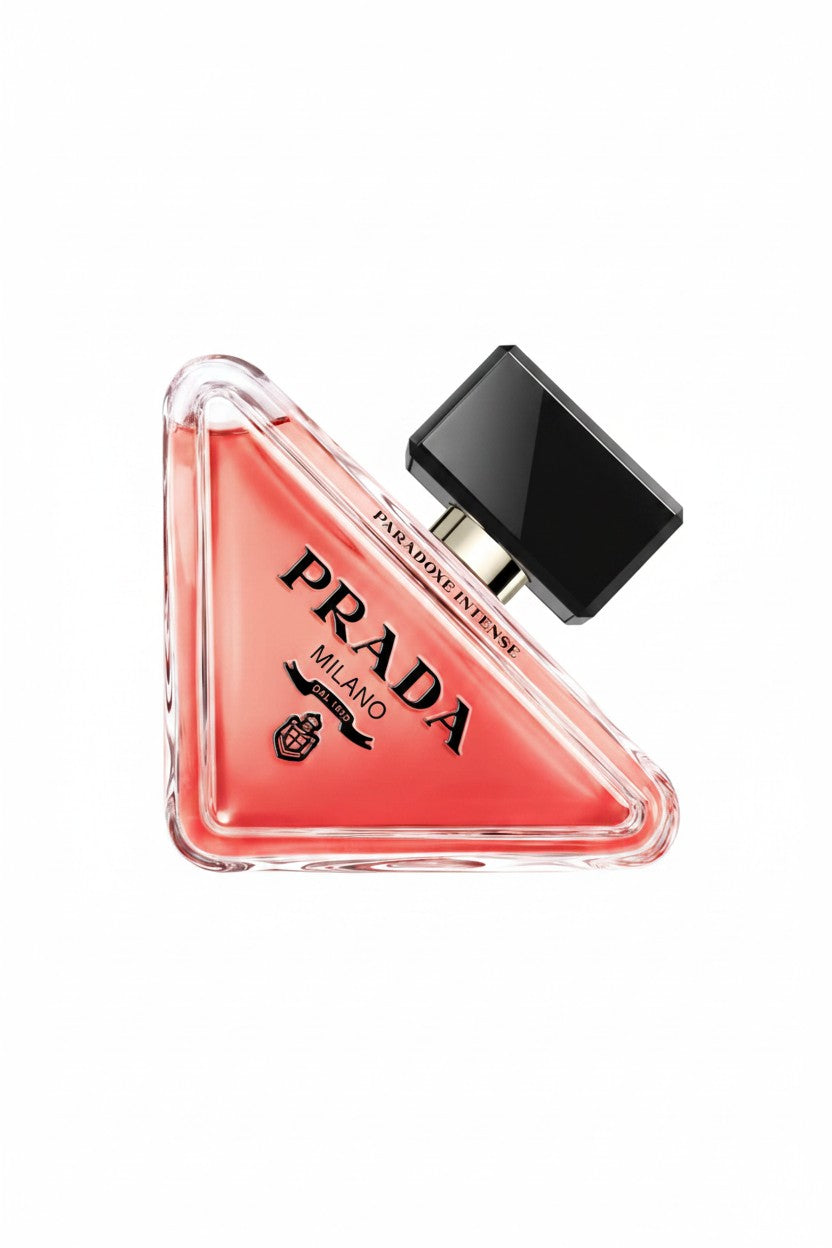 Prada Triangle Eau de Parfum bottle with a triangular clear glass body showing coral pink liquid, black Prada branding, and a glossy black cap, isolated on a white background. Prada, Monza Outlet, Monza Fashion, Shein Outlet