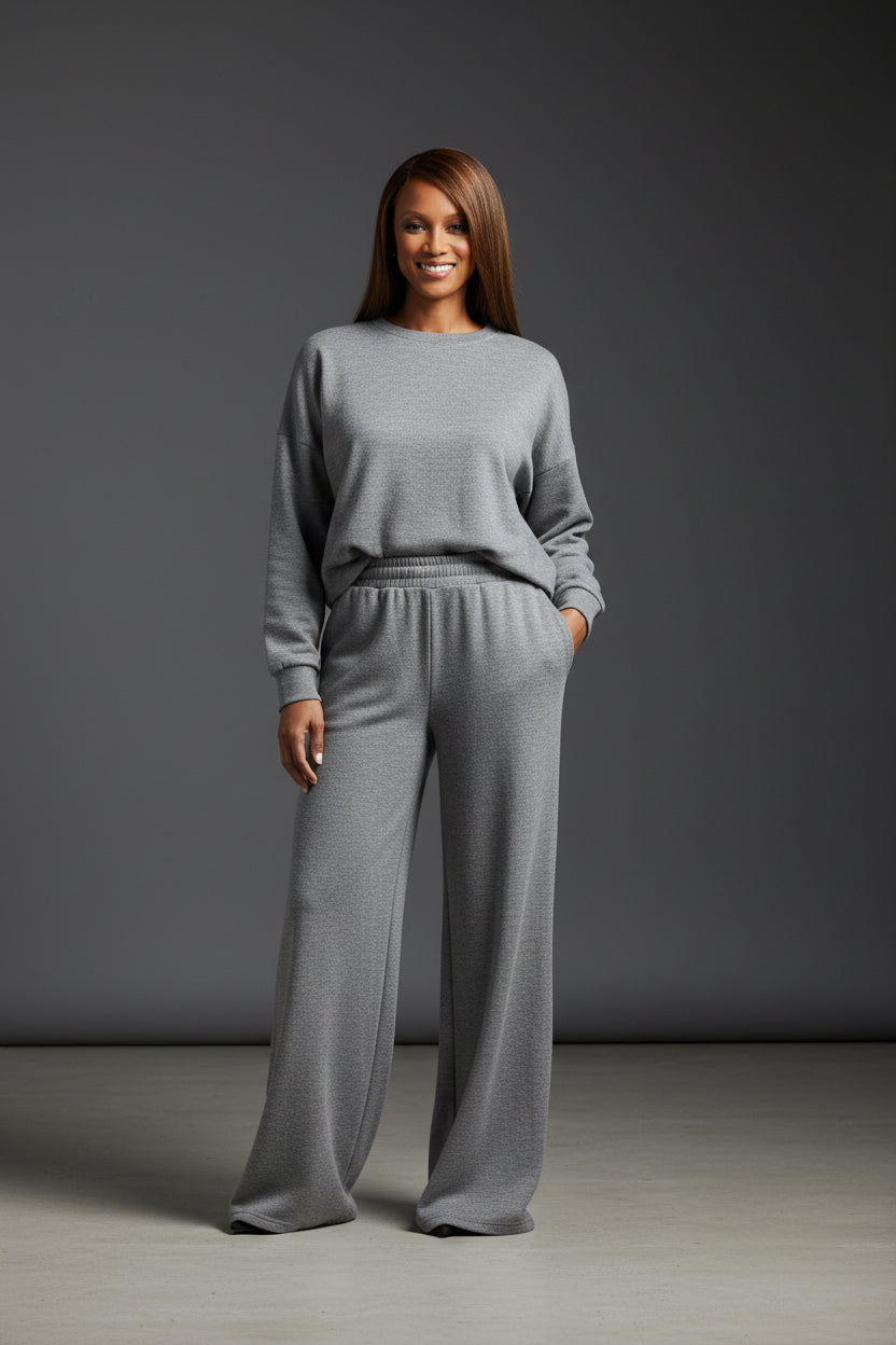 Woman wearing a gray outfit against a dark gray background. Roncato, Monza Outlet, Monza Fashion, Shein Outlet