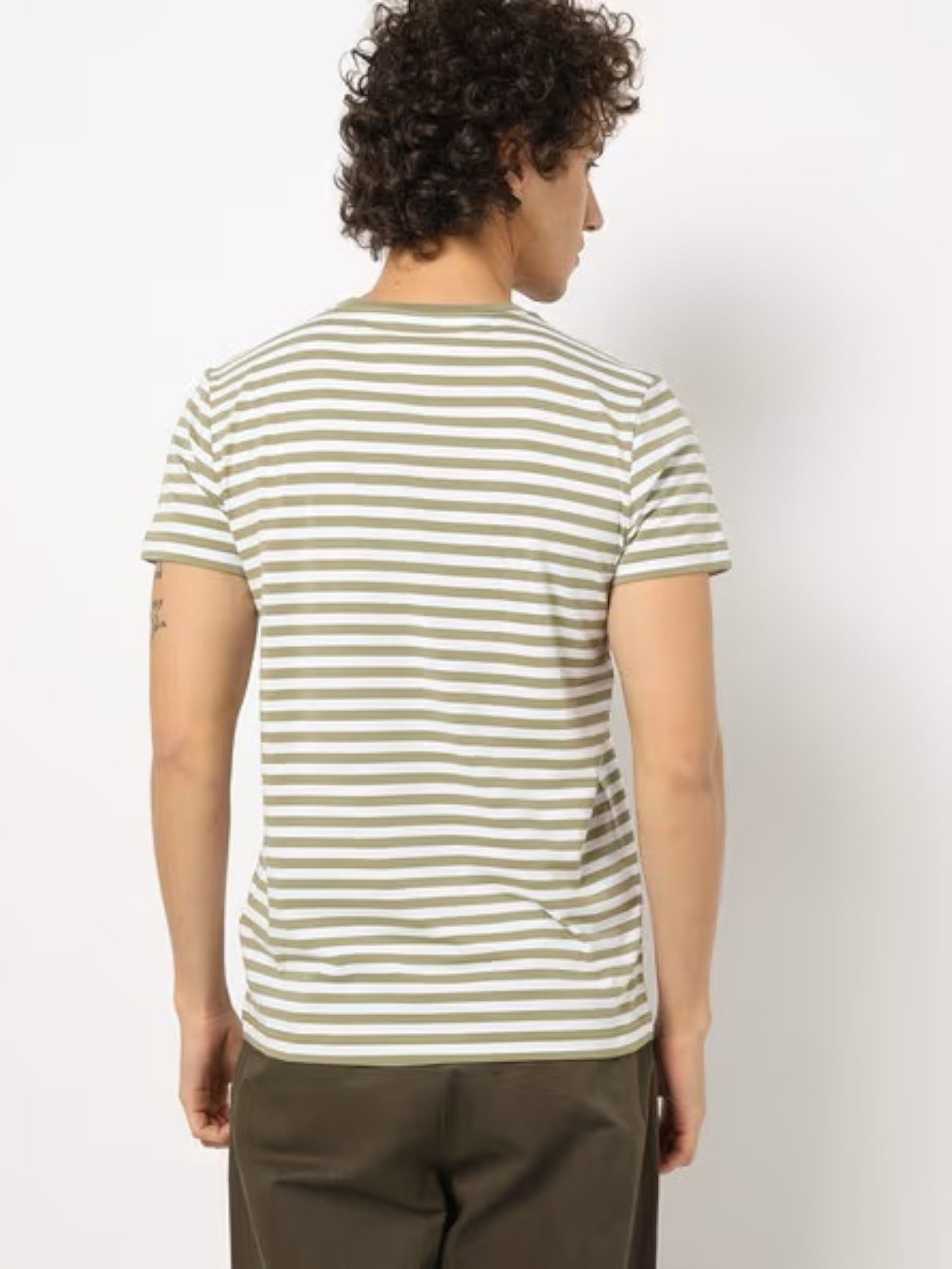 Person wearing a green and white striped t-shirt against a plain background. Tommy, Monza Outlet, Monza Fashion, Shein Outlet  