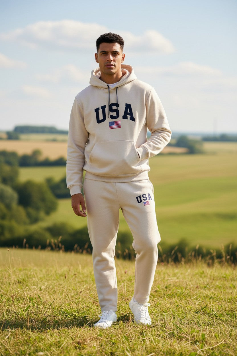 Person wearing a beige USA tracksuit standing in a field with a clear sky. Antler, Monza Outlet, Monza Fashion, Shein Outlet