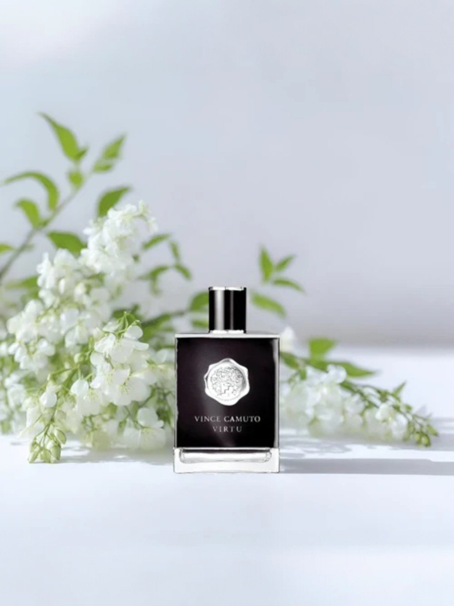 Perfume bottle with white flowers on a light background. Vince Camuto, Monza Outlet, Monza Fashion, Shein Outlet