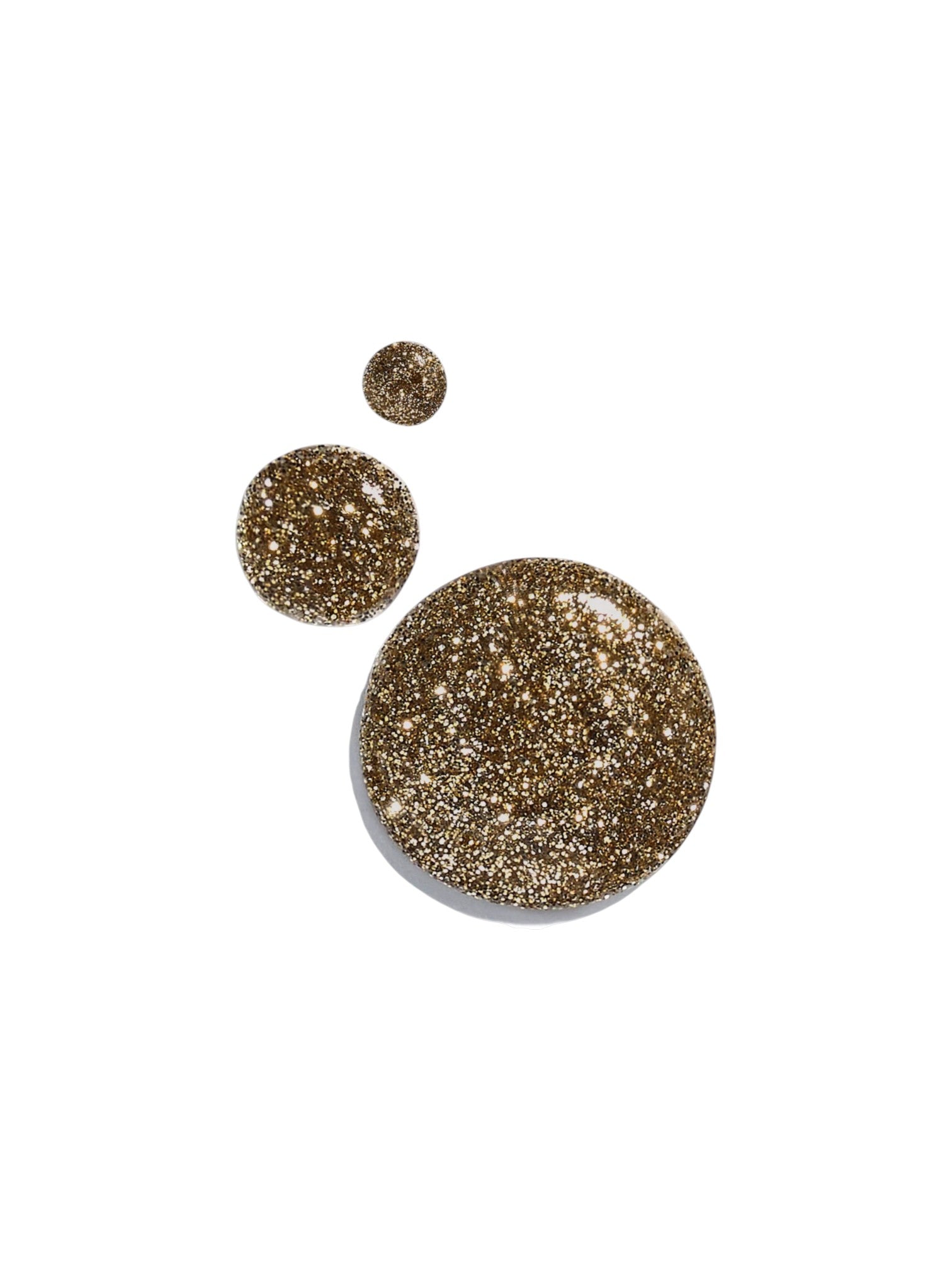 Two circular droplets of glittery gold cosmetic product, one large and one small, on a solid white background. Dolce and Gabanna, Monza Outlet, Monza Fashion, Shein Outlet