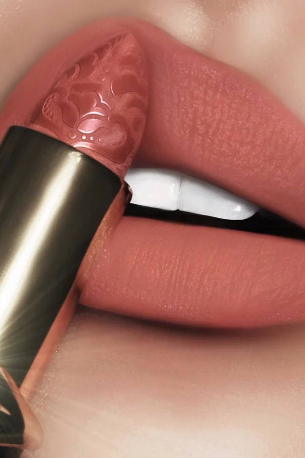 Lipstick shade Honey Haze, warm nude matte lipstick with a golden beige undertone, presented in elegant black and gold bullet packaging with gold lips design. Monza Outlet
