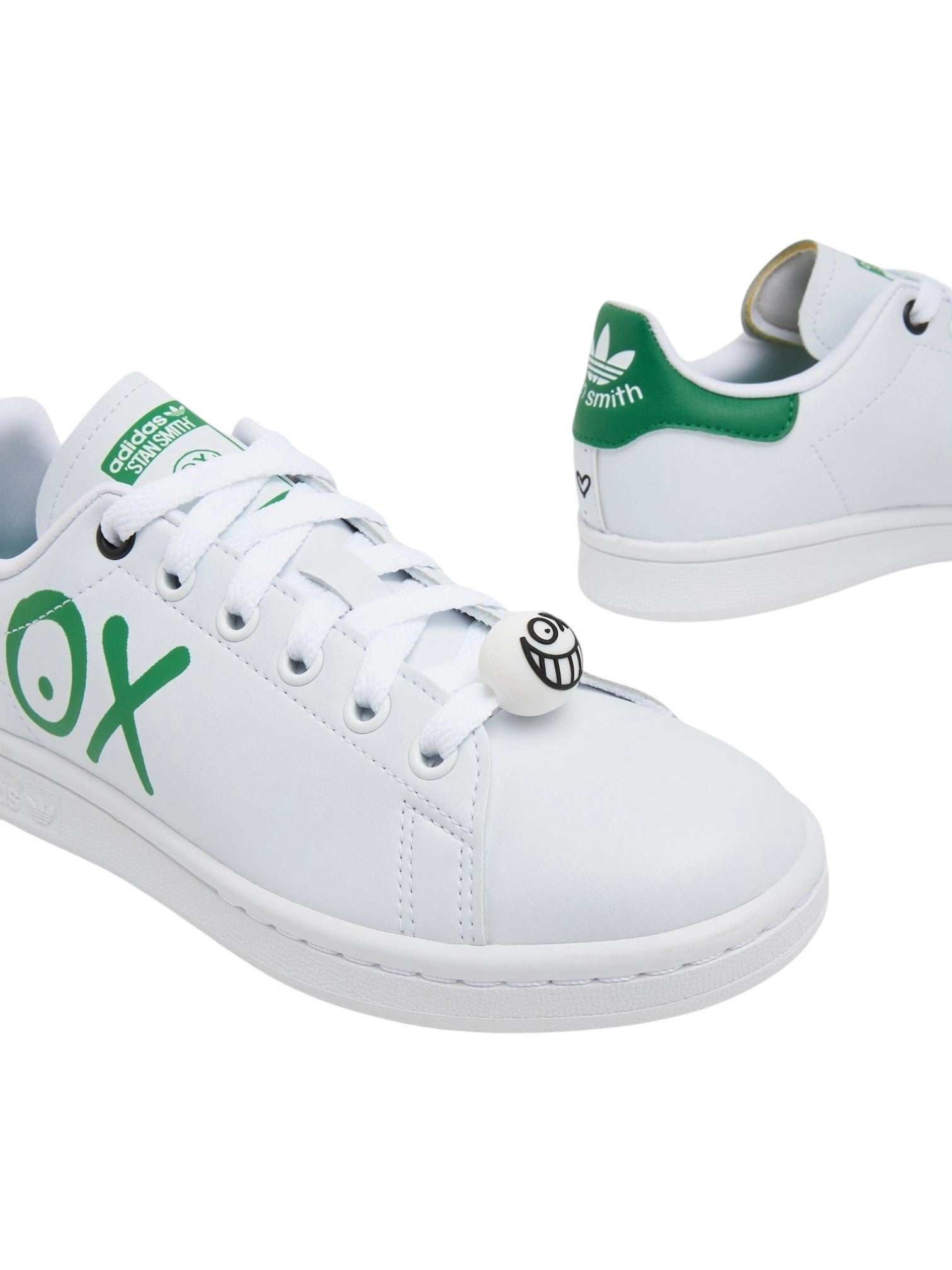 White sneakers with green accents and branding on a white background. Adidas, Monza Outlet, Monza Fashion, Shein Outlet