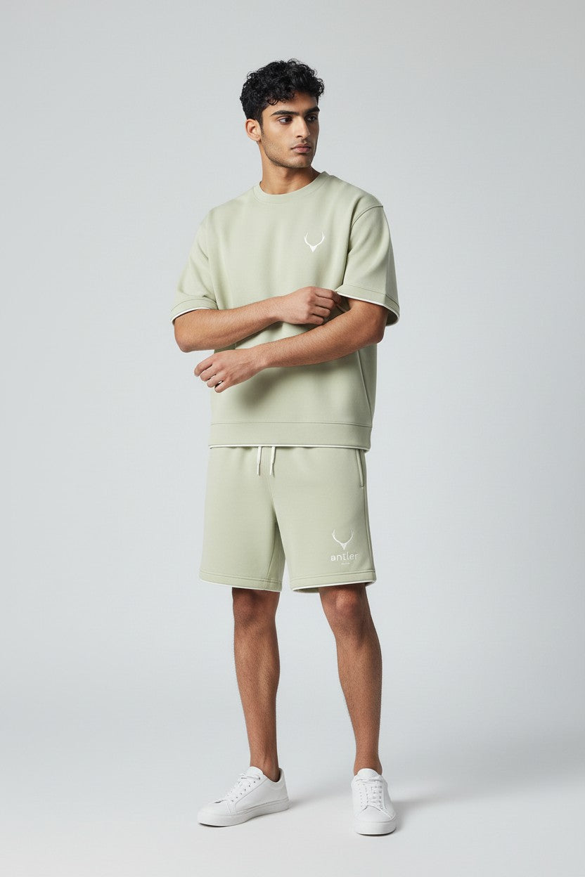 Man wearing a light green t-shirt and shorts set on a white background. Antler, Monza Outlet, Monza Fashion, Shein Outlet