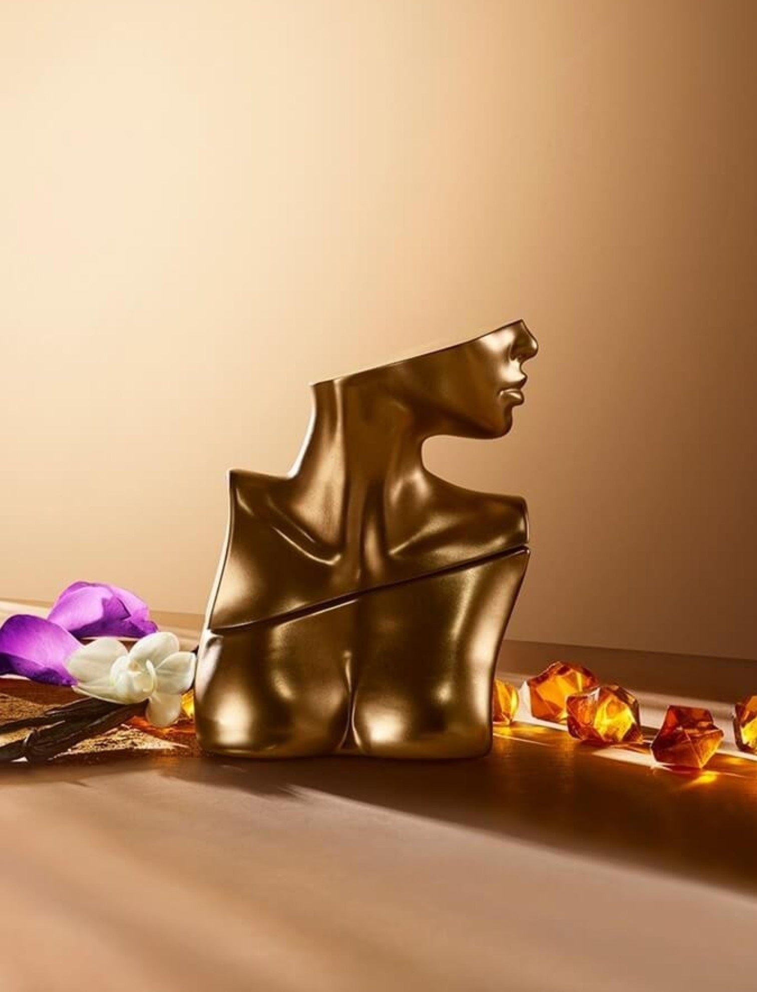 Gold sculpture of a woman's head on a beige background with decorative elements. Billie Eilish, Monza Outlet, Monza Fashion, Shein Outlet