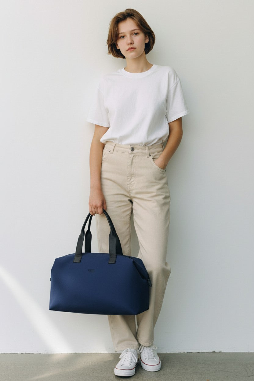 Person holding a navy blue bag against a white background. Boucheron, Monza Outlet, Monza Fashion, Shein Outlet 