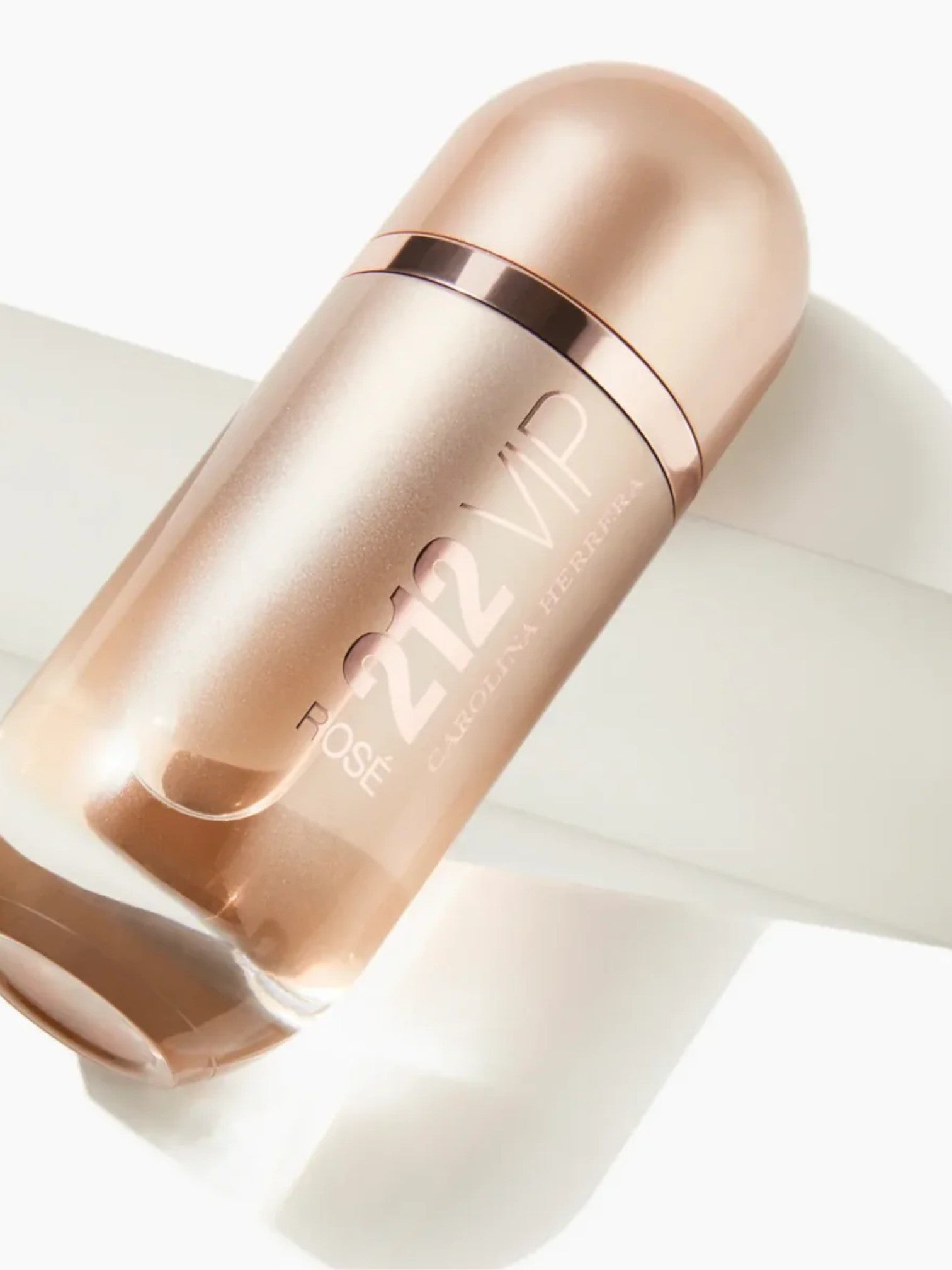 Rose gold skincare bottle on a light background. Carolina Herrera, Monza Outlet, Monza Fashion, Shein Outlet