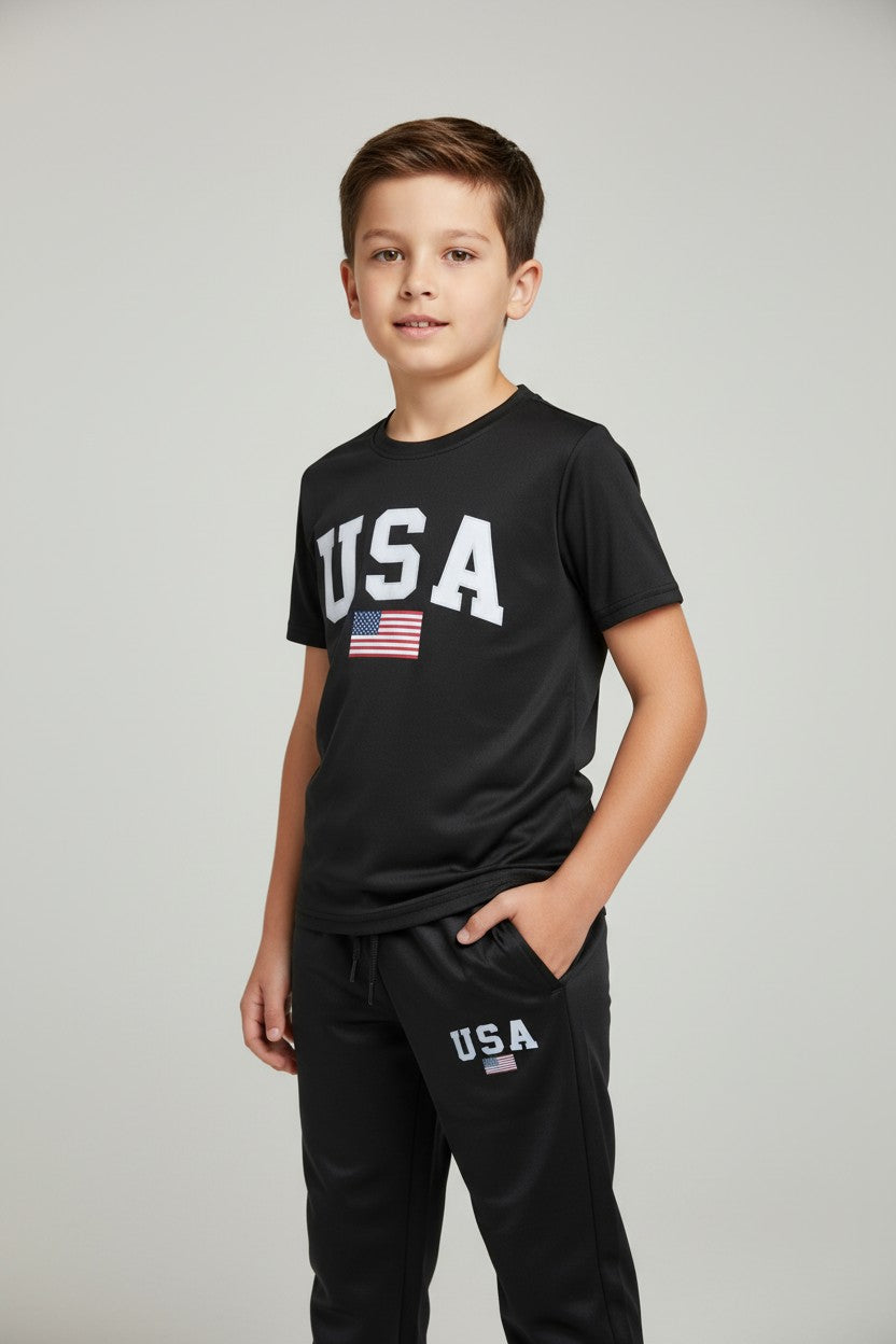 Child wearing a black USA t-shirt and pants with an American flag on a white background. Antler, Monza Outlet, Monza Fashion, Shein Outlet