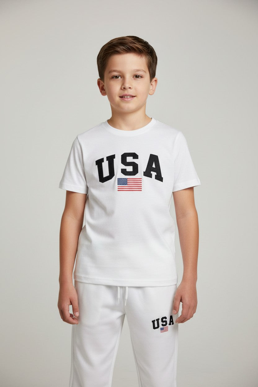 Child wearing a white USA t-shirt and pants on a plain background. Antler, Monza Outlet, Monza Fashion, Shein Outlet