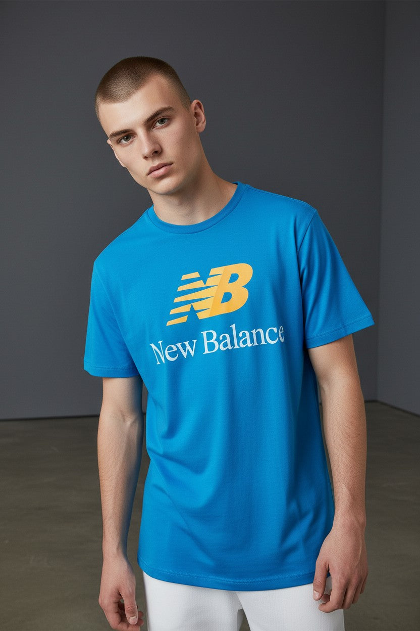 Man wearing a blue New Balance t-shirt against a brown background. New Balance, Monza Outlet, Monza Fashion, Shein Outlet