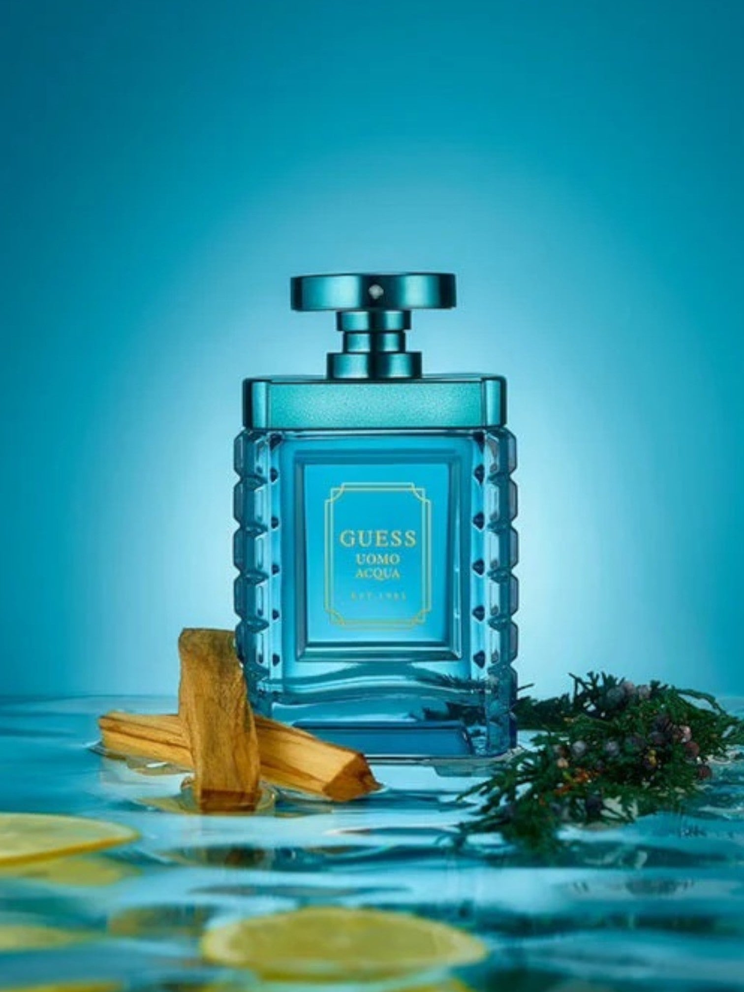 Blue Guess perfume bottle with cinnamon sticks and lavender on a blue background monza outlet, Shein outlet, monza fashion