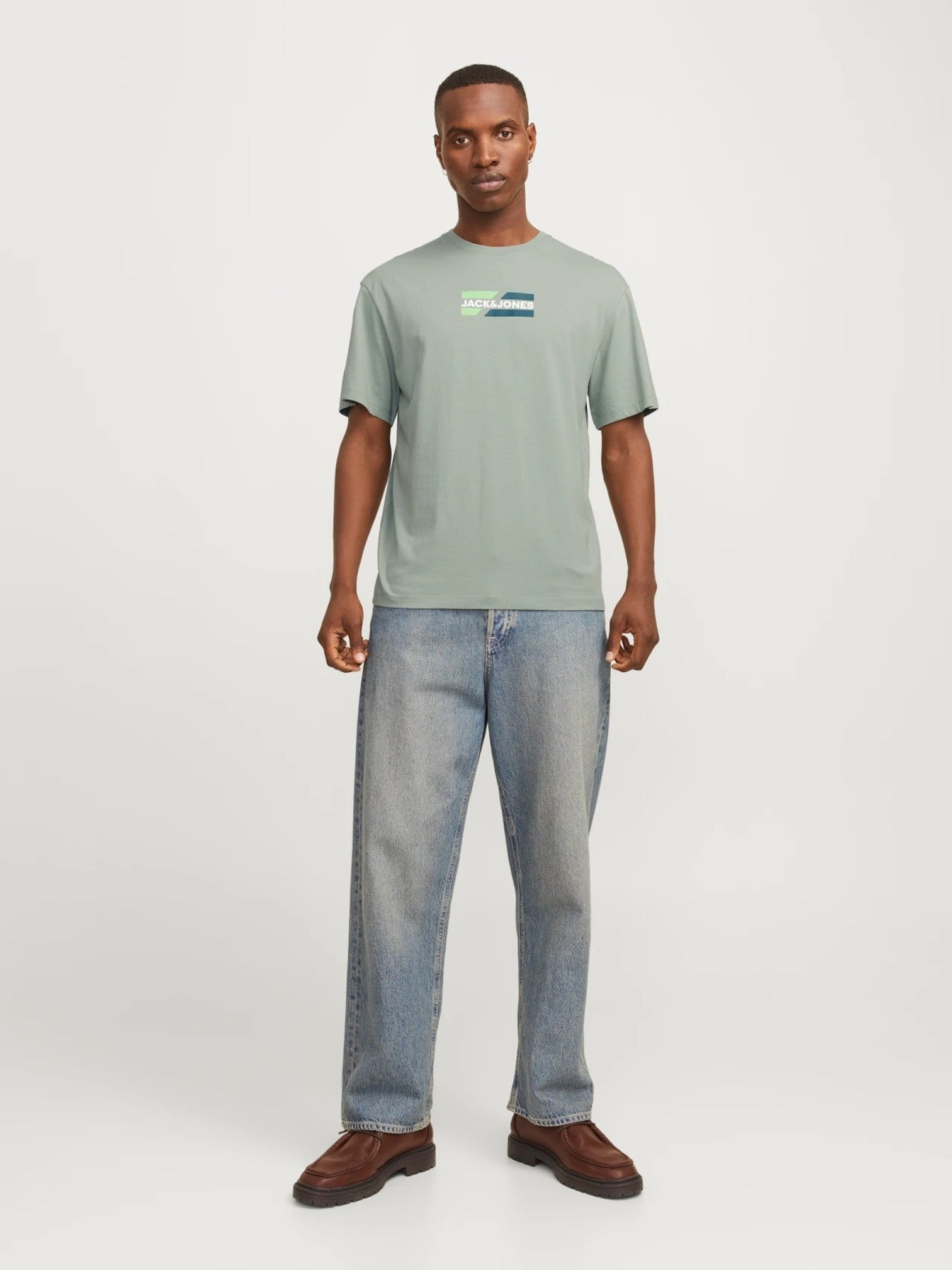 Man wearing a green t-shirt and blue jeans on a white background. Lee, Monza Outlet, Monza Fashion, Shein Outlet 