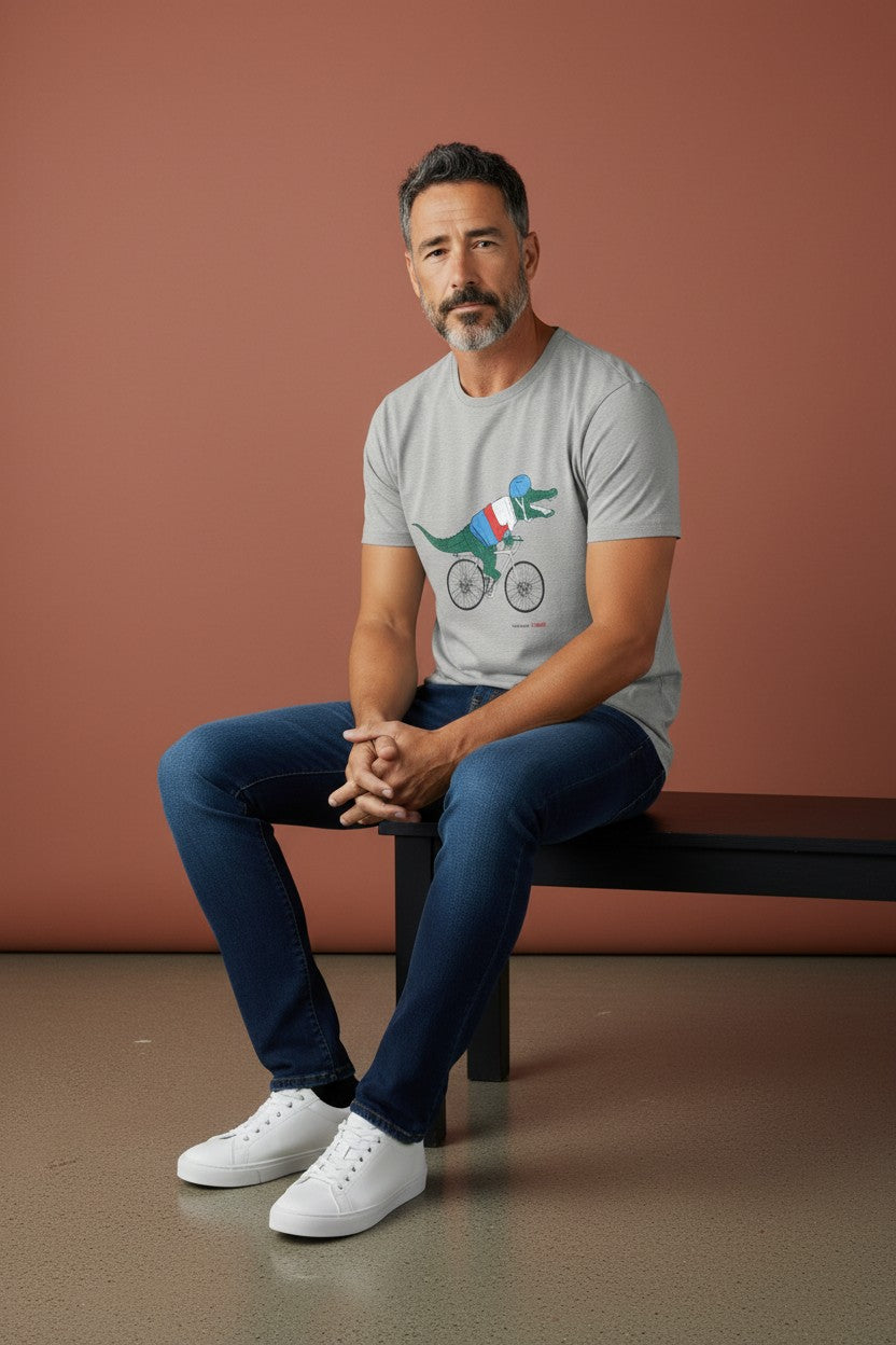 Man sitting on a bench wearing a gray t-shirt with a graphic design against a brown background. Lacoste, Monza Outlet, Monza Fashion, Shein Outlet