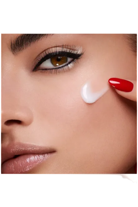 Close-up of a woman applying cream to her face with red nail polish. Monza Outlet 