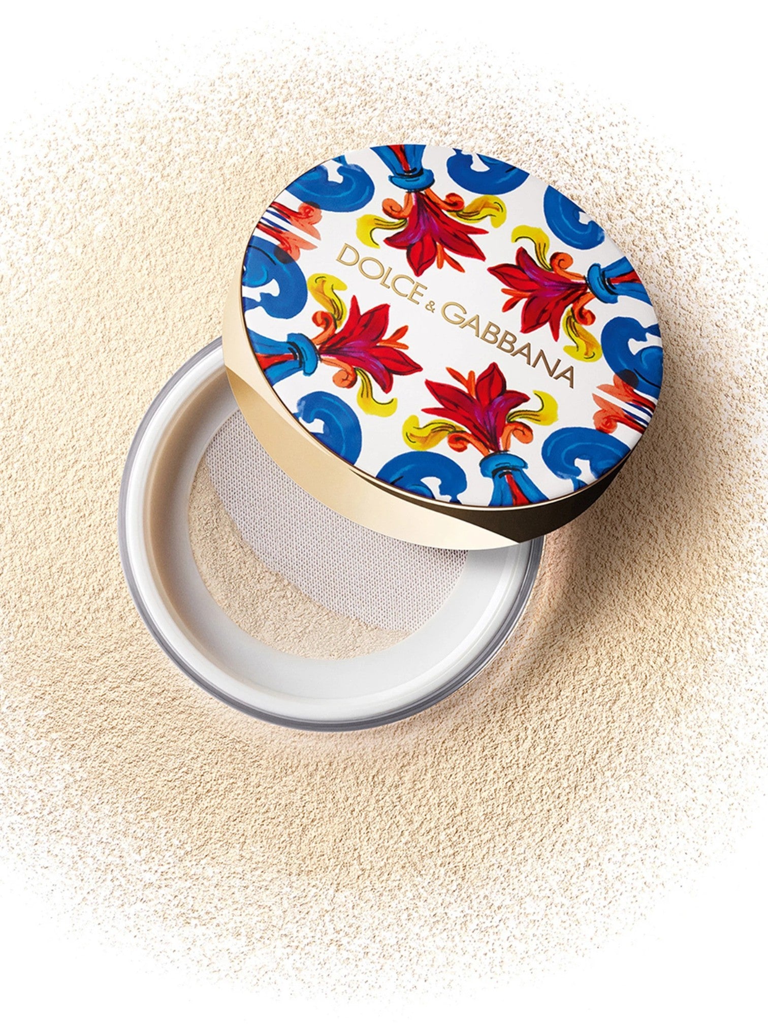 Dolce & Gabbana compact powder with colorful lid on a beige background Dolce Gabbana Monza Outlet 