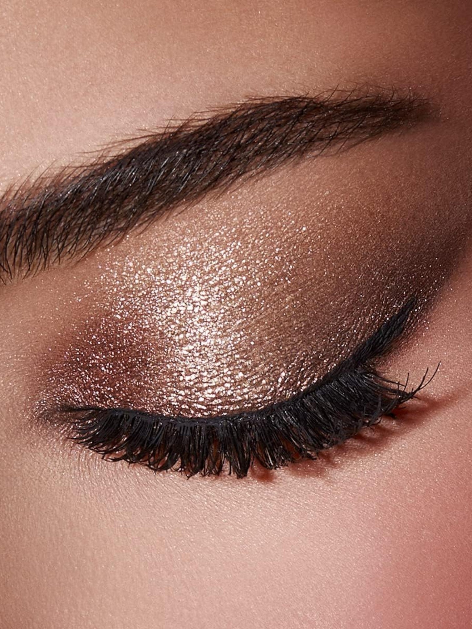 Close-up of a eye with bronze eyeshadow and long black eyelashes. Kiko Milano, Monza Outlet, Monza Fashion, Shein Outlet