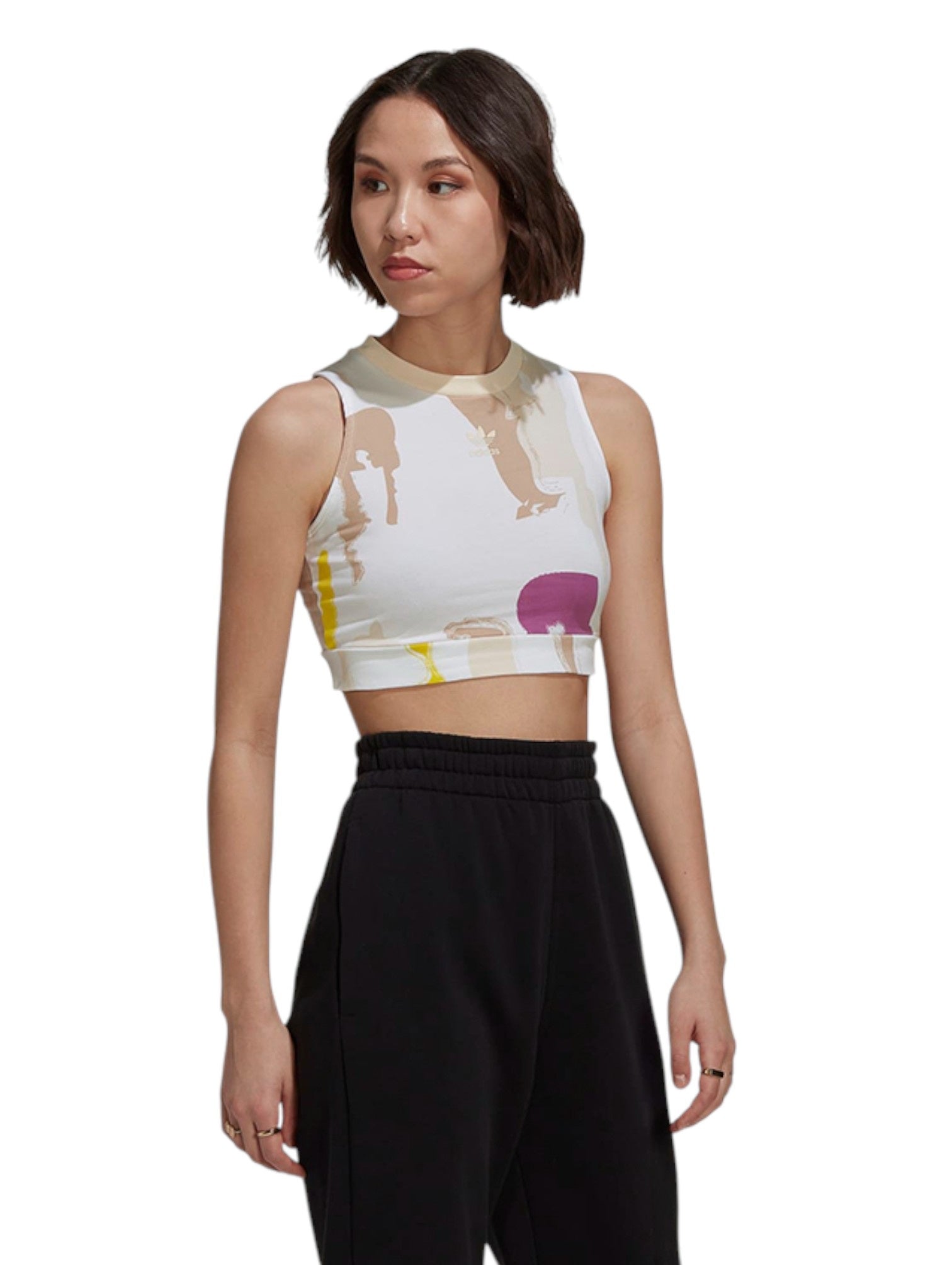 Woman wearing a sleeveless crop top with abstract design and black pants on a white background. Adidas, Monza Outlet, Monza Fashion, Shein Outlet