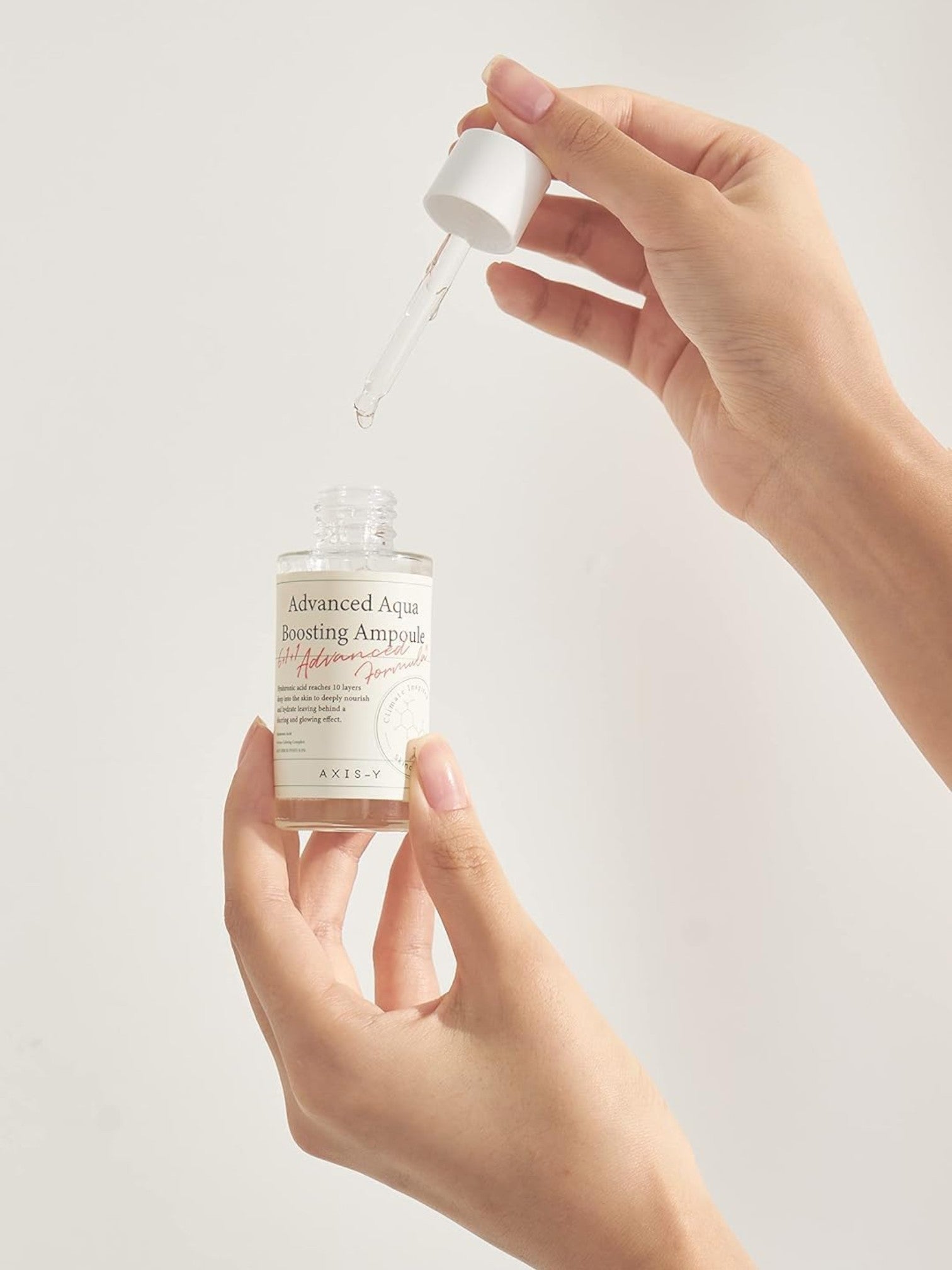 Hand holding a dropper bottle of Kiehl's Advanced Facial Serum with a light background. Axis-y, Monza Outlet, Monza Fashion, Shein Outlet