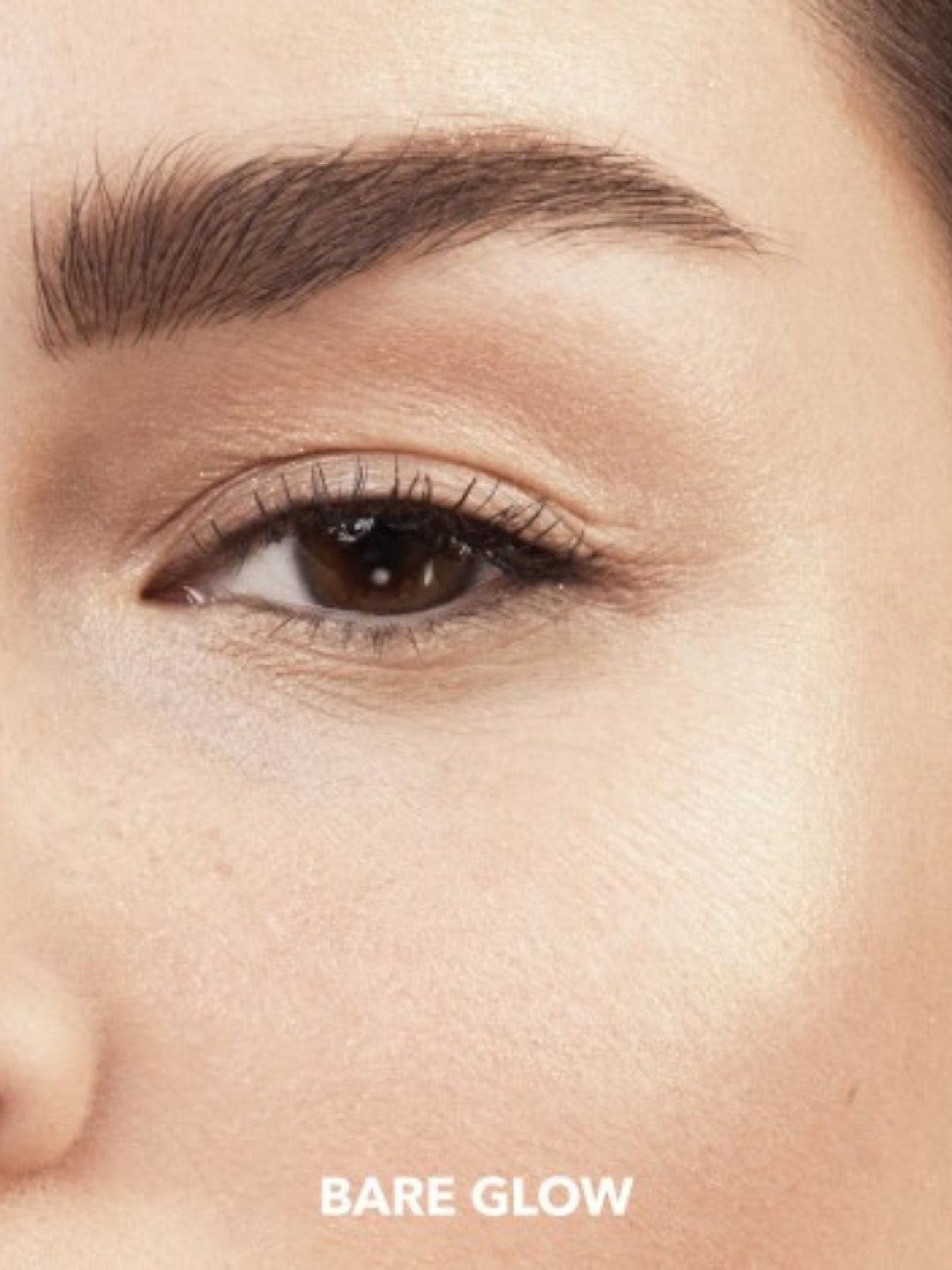 Close-up of a persons eye with the label Bare Glow on a beige background. Bobbi Brown, Monza Outlet, Monza Fashion, Shein Outlet