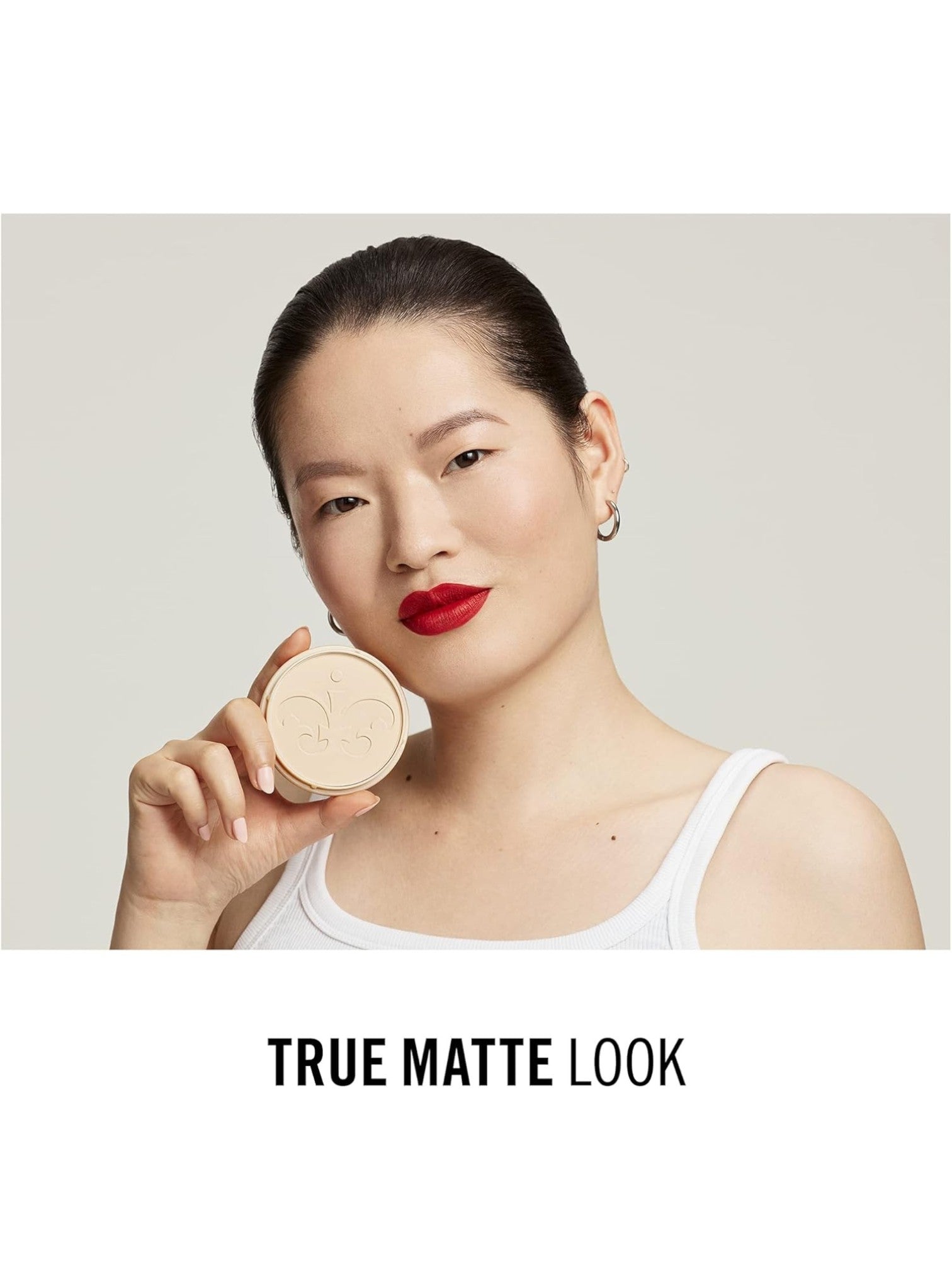 Woman holding a compact powder with 'True Matte Look' text on a neutral background. Rimmel London, Monza Outlet, Monza Fashion, Shein Outlet 