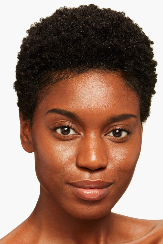 Woman with short, curly black hair on a white background Monza fashion outlet, monza outlet, shein outlet, shien outlet cosmetics, makeup, perfume