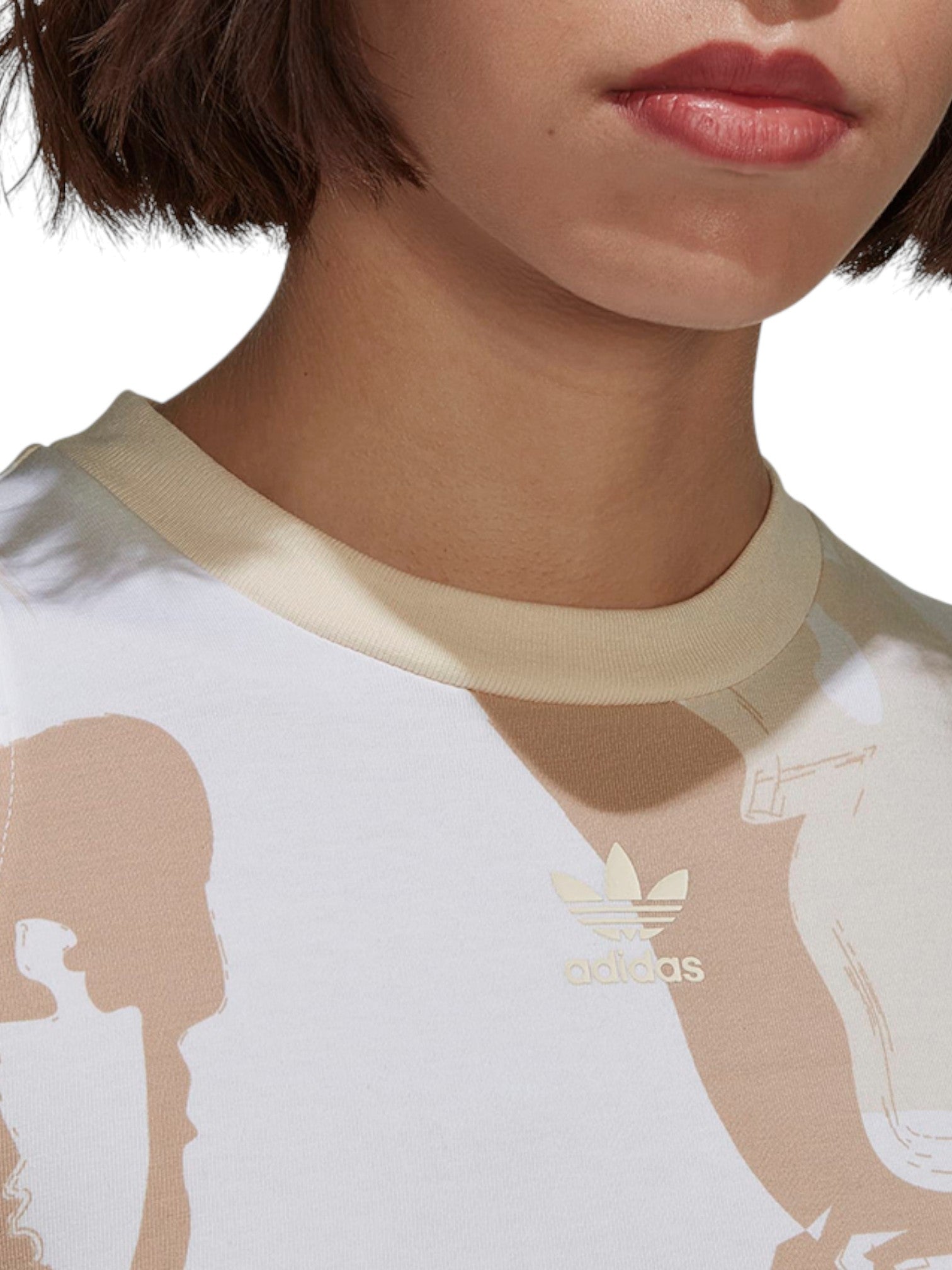 Close-up of a person wearing a white Adidas t-shirt with beige accents. Adidas, Monza Outlet, Monza Fashion, Shein Outlet