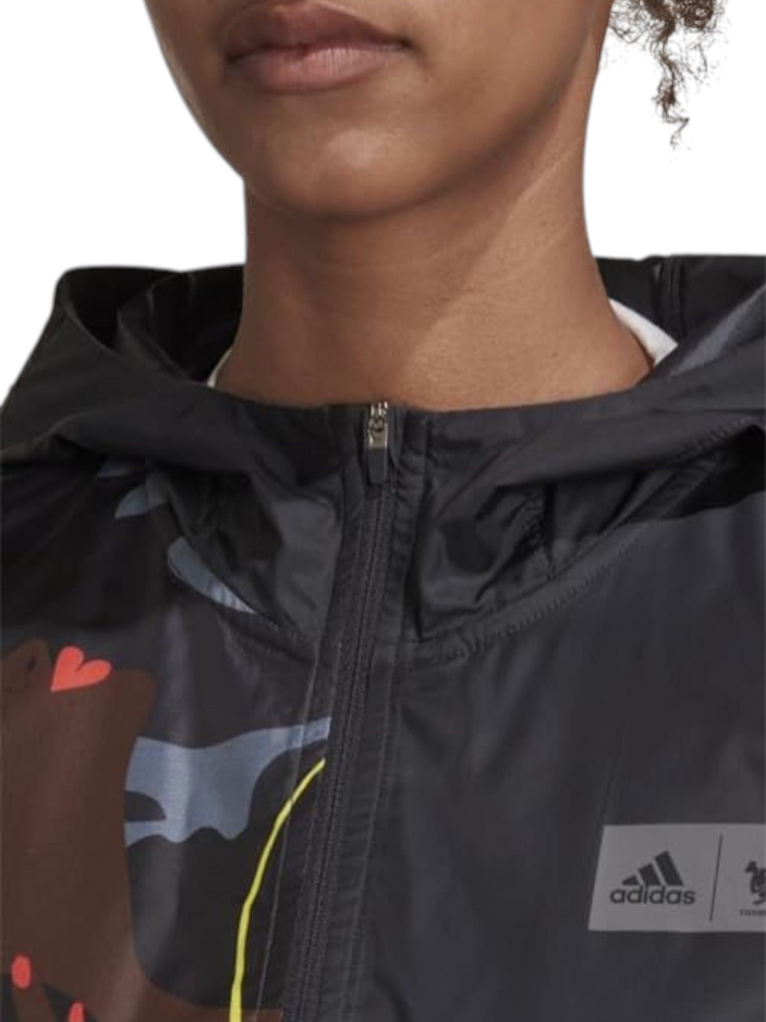 Close-up of a person wearing a black Adidas jacket with colorful graphics. Adidas, Monza Outlet, Monza Fashion, Shein Outlet