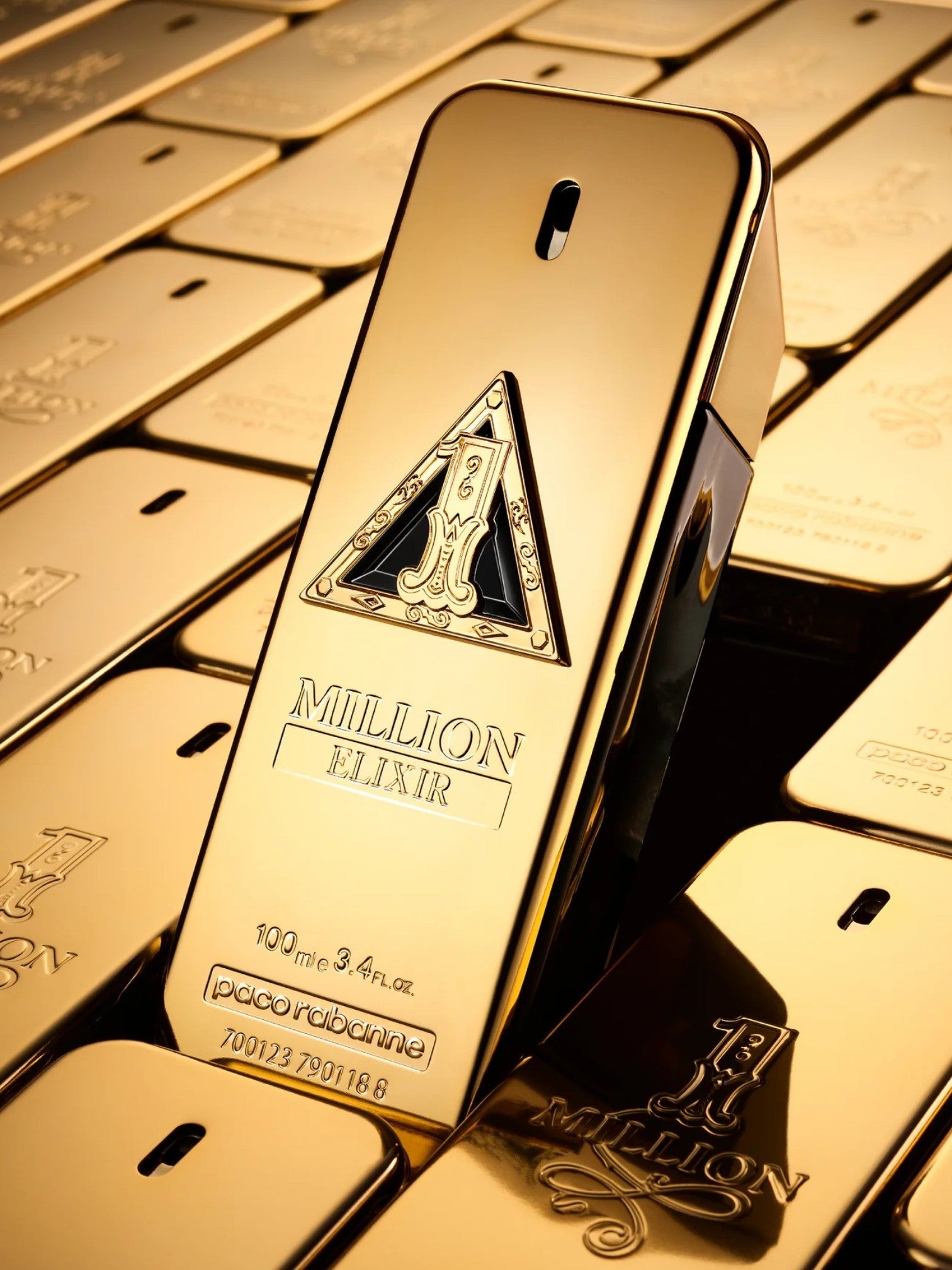 Gold bottle of Million Elixir perfume on gold bars. Paco Rabanne, Monza Outlet, Monza Fashion, Shein Outlet