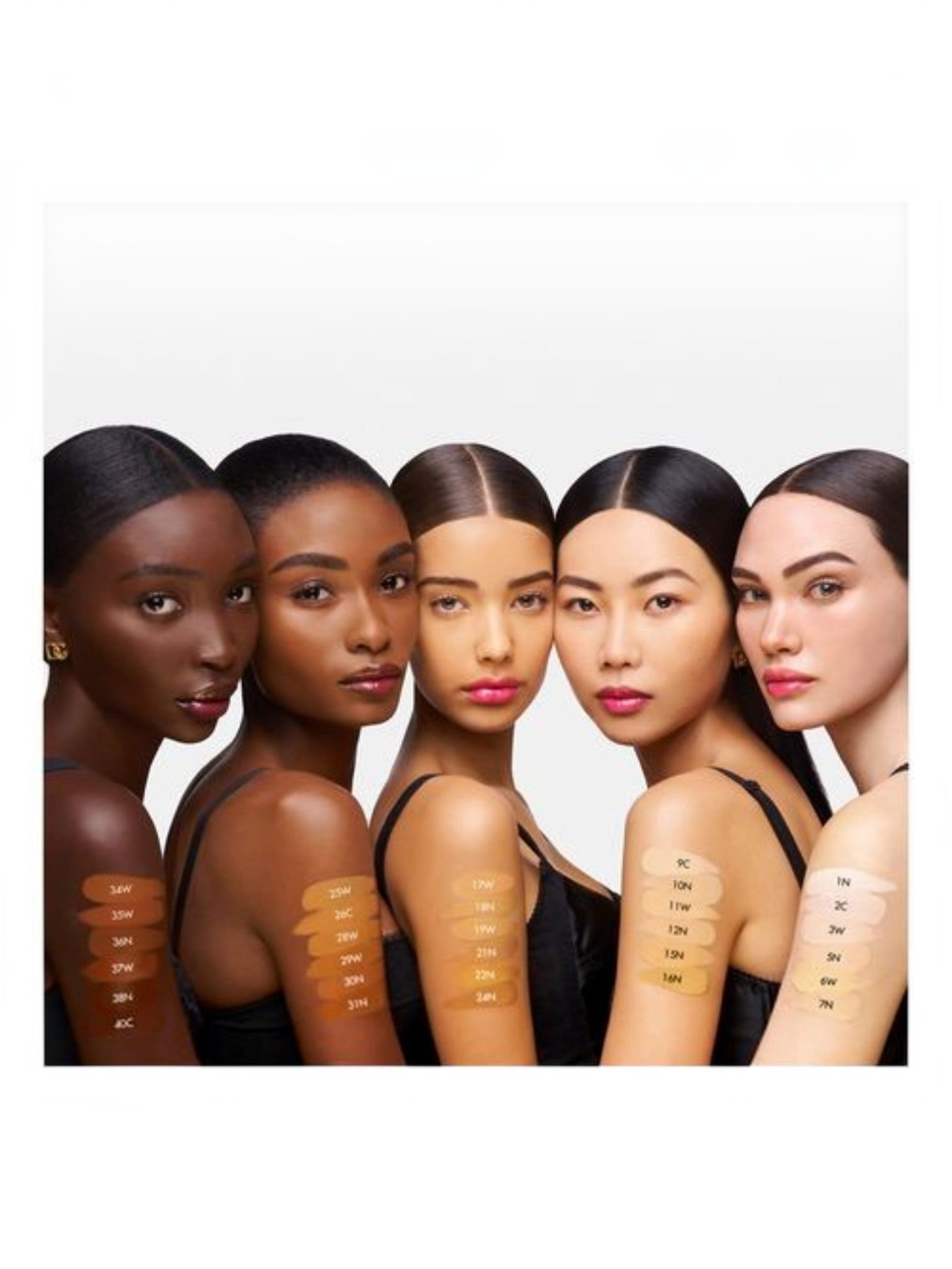 Six women with different skin tones lined up against a white background, each showing a vertical row of makeup swatches ranging from deep brown to light beige on their upper arms. Dolce & Gabbana, Monza Outlet, Monza Fashion, Shein Outlet