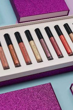 Set of lip glosses in a box with purple packaging on a light blue background Monza fashion outlet, monza outlet, shein outlet, shien outlet cosmetics, makeup, perfume