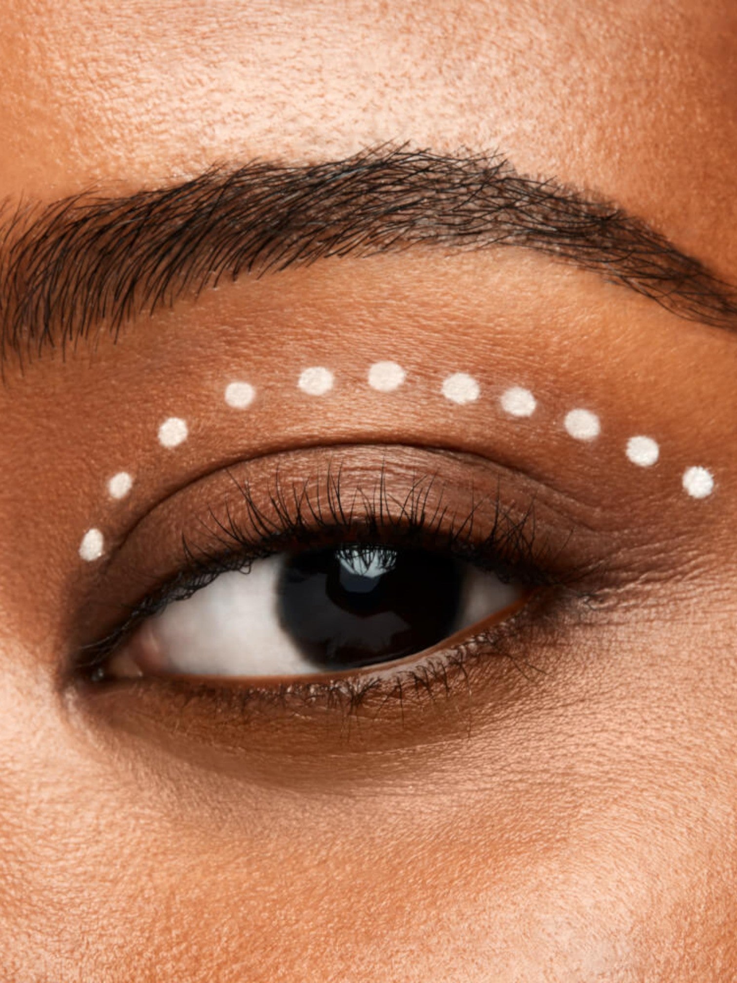 Close-up of a person's eye with white dots around the eye area. Shiseido, Monza Outlet, Monza Fashion, Shein Outlet
