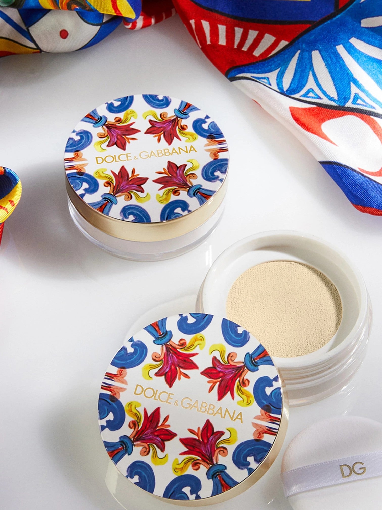 Dolce & Gabbana cosmetic compact with colorful floral design on a white background Dolce Gabbana Monza Outlet