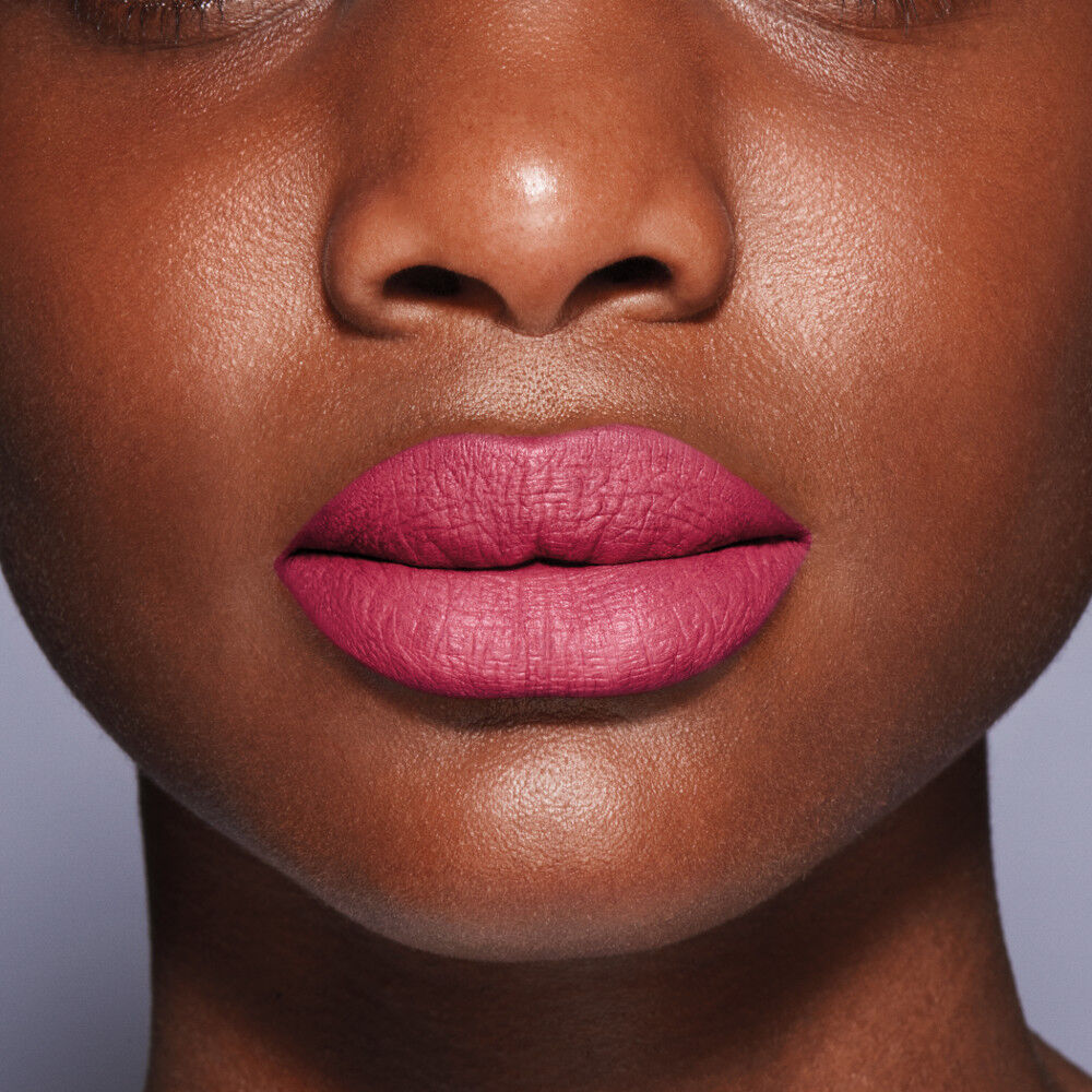 Close-up of a person's face with pink lipstick on a neutral background. Shiseido, Monza Outlet, Monza Fashion, Shein Outlet