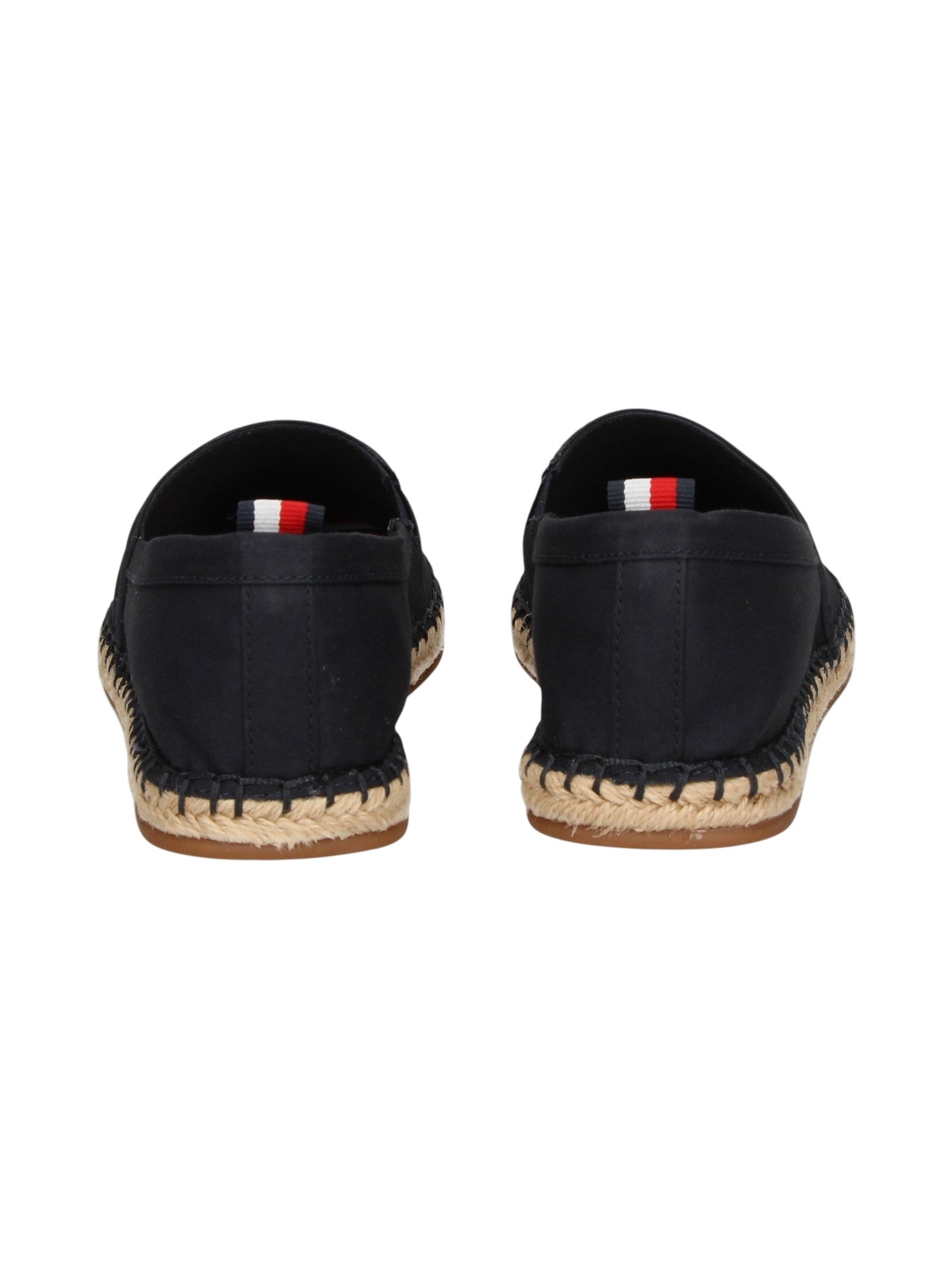 A pair of black canvas espadrille slip on shoes shown from the back, featuring a braided jute sole and a small red, white, and blue flag tab on the heel. Tommy Hilfiger, Monza Outlet, Monza Fashion, Shein Outlet